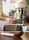 Woman washing bowl, using eco friendly sponge