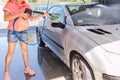 Woman washing car with pressure washer at self-service car wash station Royalty Free Stock Photo