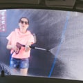 Woman washing car with pressure washer at self-service car wash station