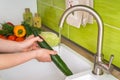 Woman washing cucumber for salad - fresh vegetables Royalty Free Stock Photo