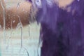 Woman washing dirty car windshield with a hose. running water wet the entire surface of the glass. abstract scene. focus on the Royalty Free Stock Photo