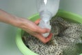 Woman is washing dress from delicate fabric by hands in basin pouring rinser. Royalty Free Stock Photo