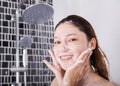 Woman washing face in shower foaming