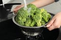 Woman washing fresh green broccoli in kitchen sink Royalty Free Stock Photo