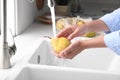 Woman washing fresh ripe pear in kitchen, closeup Royalty Free Stock Photo