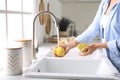 Woman washing fresh ripe pears in kitchen Royalty Free Stock Photo