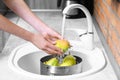 Woman washing fresh ripe pears in kitchen sink Royalty Free Stock Photo