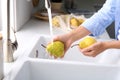 Woman washing fresh ripe pears in kitchen Royalty Free Stock Photo