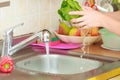 Woman washing fresh vegetables in kitchen Royalty Free Stock Photo