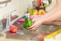 Woman washing fresh vegetables in kitchen Royalty Free Stock Photo