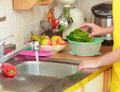 Woman washing fresh vegetables in kitchen Royalty Free Stock Photo