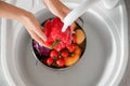 Woman washing fresh vegetables in kitchen sink, top view Royalty Free Stock Photo