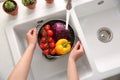 Woman washing fresh vegetables in kitchen sink, top view Royalty Free Stock Photo