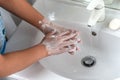 Woman washing hand with soap foam and tap water in bathroom. Hand clean under faucet on sink for personal hygiene to Royalty Free Stock Photo