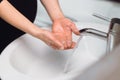woman Washing hands with soap and disinfectant under the faucet with water at home in bathroom Royalty Free Stock Photo