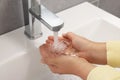 Woman washing hands with water from tap in bathroom, closeup Royalty Free Stock Photo