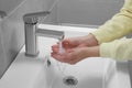 Woman washing hands with water from tap in bathroom, closeup Royalty Free Stock Photo