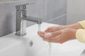 Woman washing hands with water from tap in bathroom, closeup Royalty Free Stock Photo