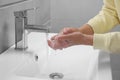 Woman washing hands with water from tap in bathroom, closeup Royalty Free Stock Photo