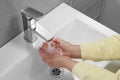 Woman washing hands with water from tap in bathroom, closeup Royalty Free Stock Photo