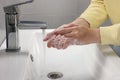 Woman washing hands with water from tap in bathroom, closeup Royalty Free Stock Photo