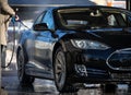 Woman washing her car in a manual carwash