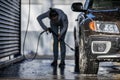 Woman washing her car in a manual carwash