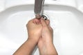 Woman washing her hands in the sink under water. Royalty Free Stock Photo