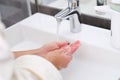 Woman washing her hands under water from tap in bathroom closeup Royalty Free Stock Photo
