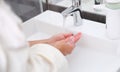 Woman washing her hands under water from tap in bathroom closeup Royalty Free Stock Photo