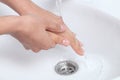 Woman washing her hands under a waterjet