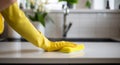 woman washing kitchen counter with sponge in yellow rubber gloves Royalty Free Stock Photo
