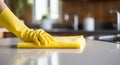 woman washing kitchen counter with sponge in yellow rubber gloves Royalty Free Stock Photo