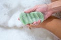 Woman washing legs with konjac sponge in bathroom, close up. Zero waste bath product Royalty Free Stock Photo