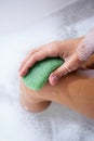Woman washing legs with konjac sponge in bathroom, close up. Zero waste bath product Royalty Free Stock Photo