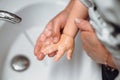 woman washing little baby boys hands. Hygiene and disinfection of hands at home with soap and tap water Royalty Free Stock Photo