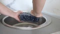 Woman washing ripe sweet blueberry in a kitchen sink under water jet, cleaning fresh juicy fruits in plastic containers of bacteri