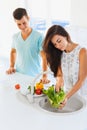 Woman washing vegetables in the sink and man standing next to he Royalty Free Stock Photo