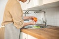 A woman washing vegetables at a sink and preparing fresh vegetable for her food in the kitchen Royalty Free Stock Photo