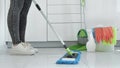 Woman washing white kitchen floor with special swob, cleaning service, close-up 4k