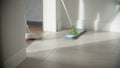 Woman washing white kitchen floor with special swob, cleaning service, close-up