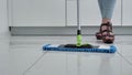 Woman washing white kitchen floor with special swob, in wedge shoes close-up 4k