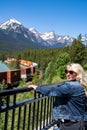 Woman watches a freight train pass through Morants Curve in Banff National Park