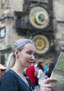 Woman watches the map of the city on background of historical medieval astronomical Clock on the Old Town Hall in Prague, Czech Re Royalty Free Stock Photo