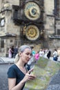 Woman watches the map of the city on background of historical medieval astronomical Clock on the Old Town Hall in Prague, Czech Re Royalty Free Stock Photo