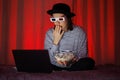 woman watches movie at home with 3 d glasses and eats popcorn