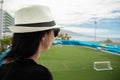 A woman watches from a tall football field