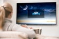 Woman watches tv with 4k ultra hd resolution