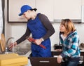 Woman watching as worker repairing water lines Royalty Free Stock Photo