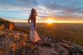 Woman watching blissful sunsets from hidden cliff ledges Royalty Free Stock Photo